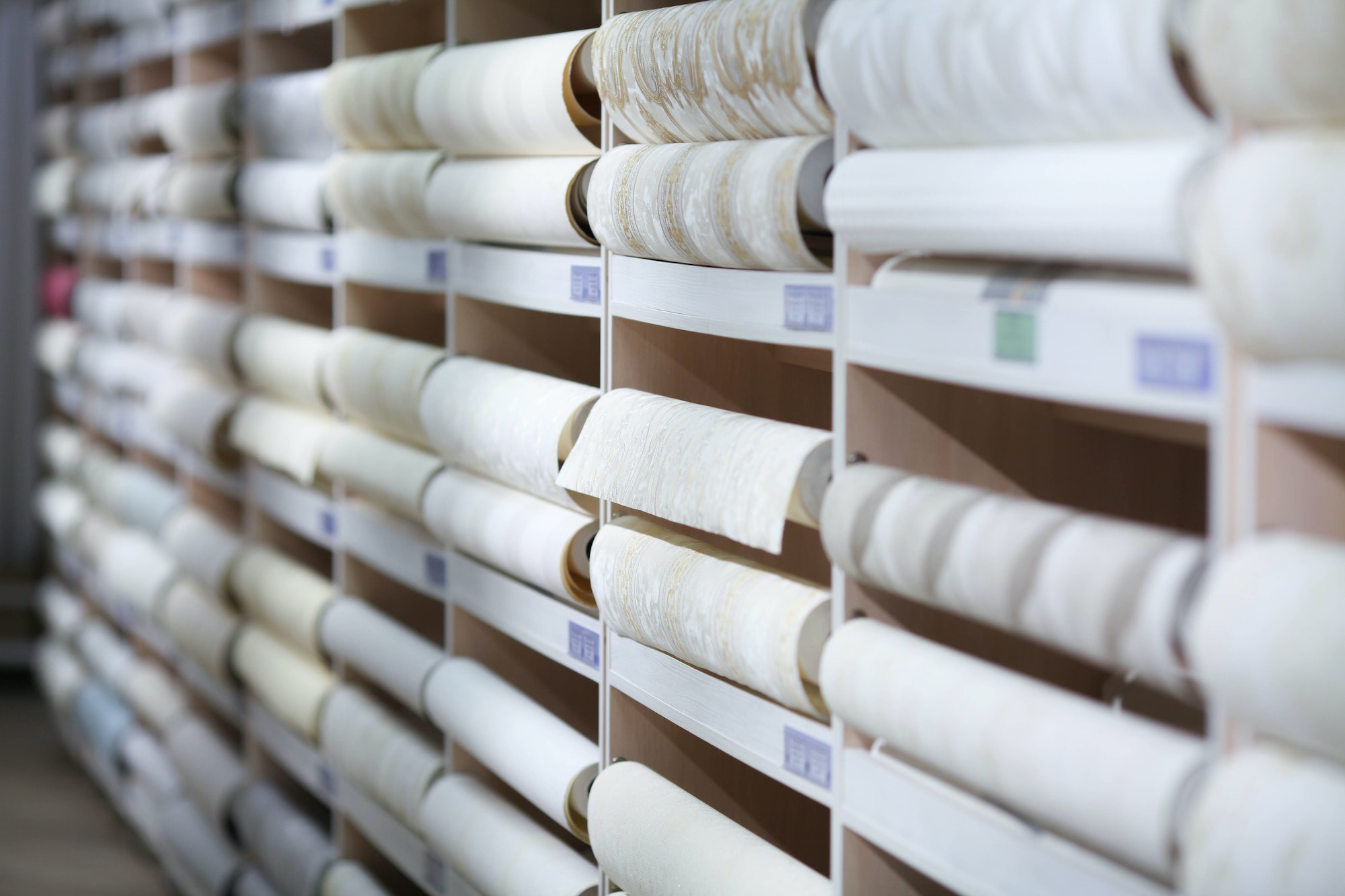 Wall-papers is in a shop. Samples of different wallpapers on store window racks